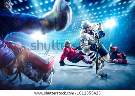 Hockey players shoots the puck and attacks Royalty-Free Stock Photo #1012355425