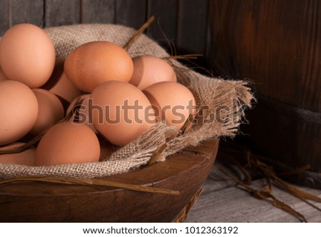 Closeup of brown chicken eggs in a wooden bowl with a rustic background