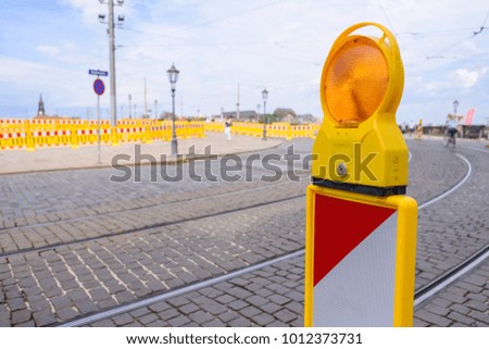 Yellow flashing light standing at road construction site. Road works concept.