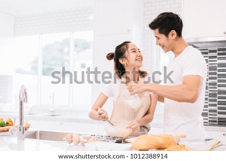 Portrait of a happy young couple cooking in the kitchen at home.