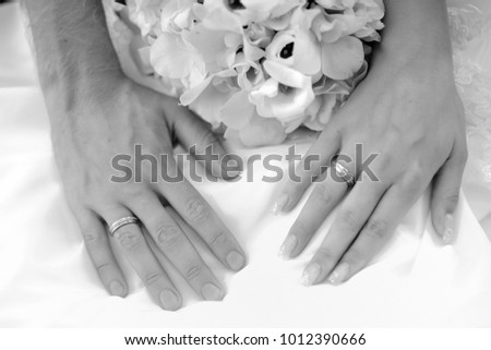 Hands of newlyweds with wedding rings. Black and white.