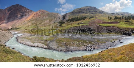Mountain valley, above a river,
panorama landscape, Altay. Shepherd's farm on the river bank, mountain pasture.