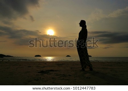 Pretty girl with sea and sunset silhouette. 