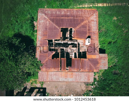 aerial shot from above of an abandoned house with a broken roof