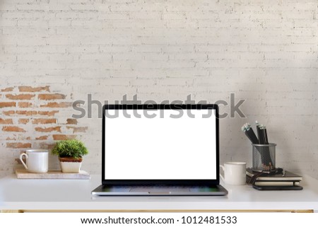 Mockup blank screen laptop on desk. Workspace with laptop and office supplies.