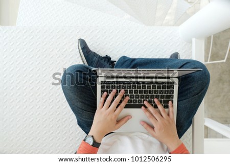 Man using laptop computer while sitting on white floor background, top view, people and technology, lifestyles