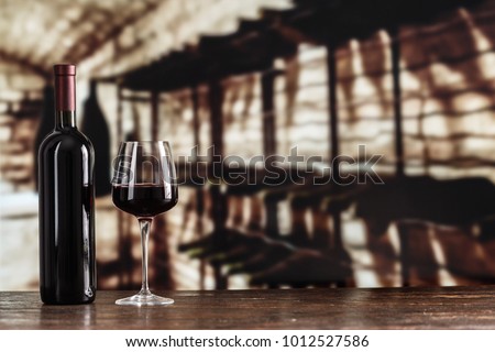 red wine in a glass on the background of a cellar, vintage picture for a wine card
