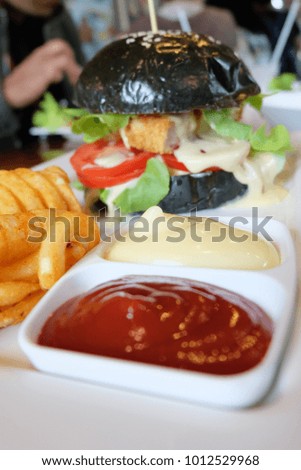 Black burger with mayonnaise and ketchup, fast food concept