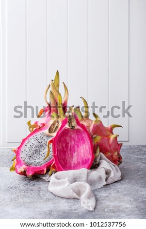 Fresh organic Pitahaya dragon fruit cut in halves and served on the white board. Copy space