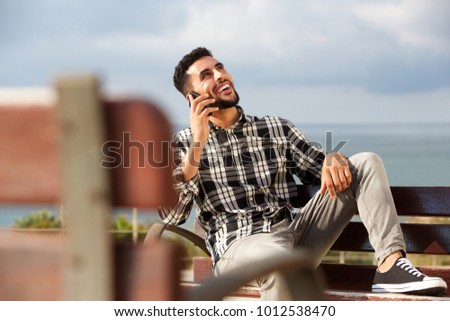 Portrait of cool young arabic man talking on mobile phone outdoors