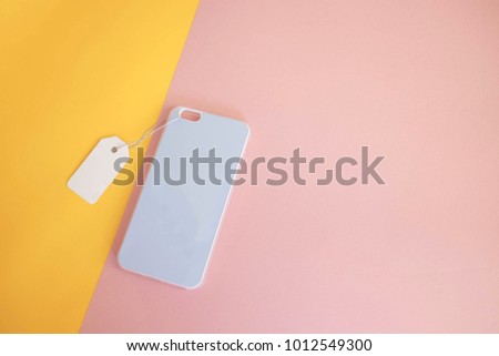 Colorful concept : Top view of mock up clear phone case pastel blue on pink and yellow paper color background, copy space, branding, corporate