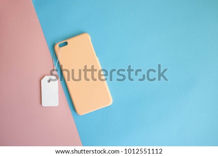 Pastel and colorful concept : Top view of mock up clear phone case pastel yellow on pink and blue paper color background, copy space, branding, corporate