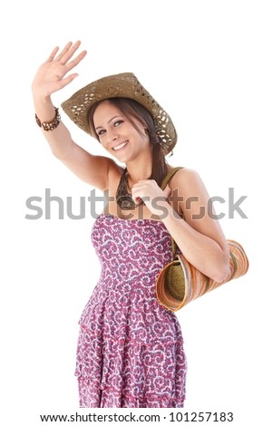 Attractive young girl in straw hat waving and smiling at summertime.