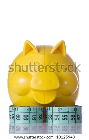 yellow piggy bank and measuring tape, on white background