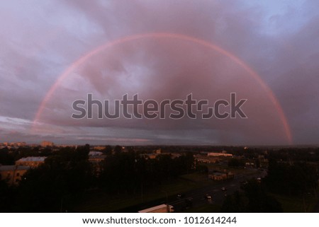 photo of the full rainbow in the town while sunset is going