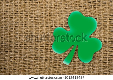 Paper sheet symbol of St. Patrick's Day. Green clover in the shape of heart. Wooden background.