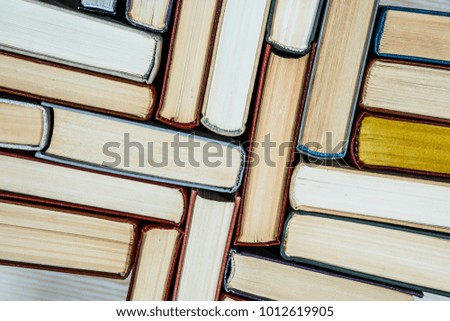 Chaotic stack of old books pastel colors, selective focus with copy space