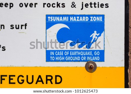 Blue sign showing danger of large tsunami waves