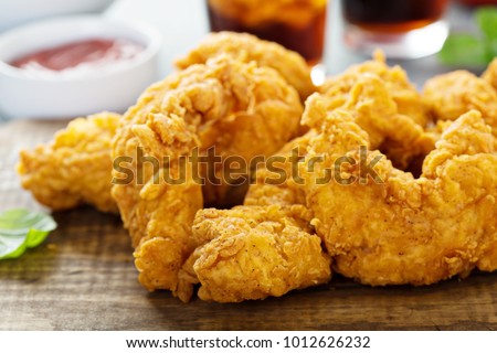 Breaded chicken tenders with ketchup, salad and soda Royalty-Free Stock Photo #1012626232