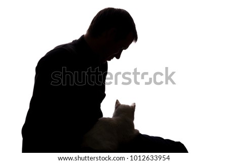 Young man with a kitten in his hands - silhouette