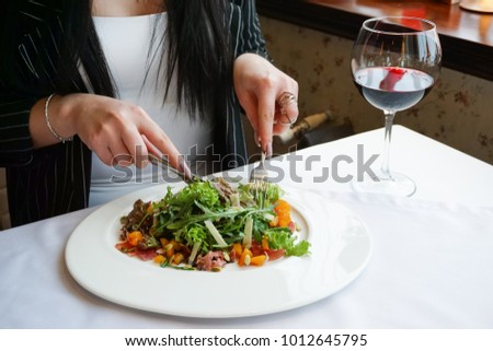 girl eating a salad in a restaurant
