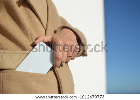 Closeup view of person holding using mobile smart phone. Sunny day outdoor. Back side top view display mock up design background for texting, talking, GPS navigation, modern communication technology