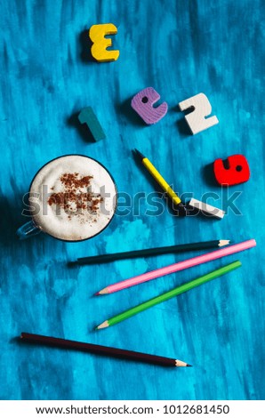 a cup of hot coffee with chocolate. figures with pencils