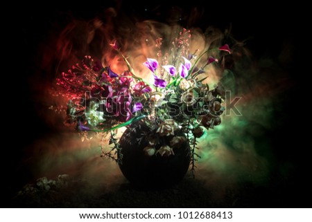 Picturesque purple spring flowers in glass vase standing in a row on a dark background with stars with light and fog. Flower concept. Dark decoration background