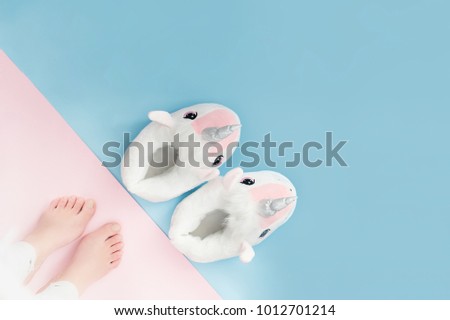 pop art pair of fluffy white unicorn slippers on pastel colour background  Royalty-Free Stock Photo #1012701214