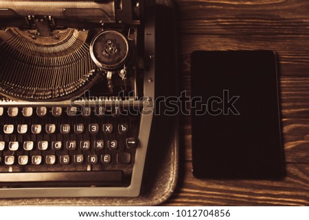 typewriter and a modern gadget. new technology.