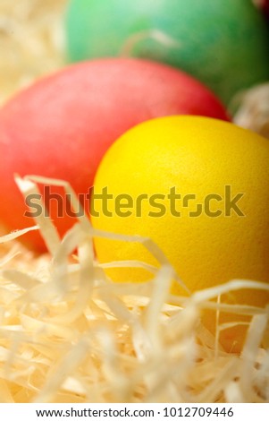 Easter egg yellow,red, gren.Colored chicken egg .On hay background.Soft Easter background. Selective focus .Closeup