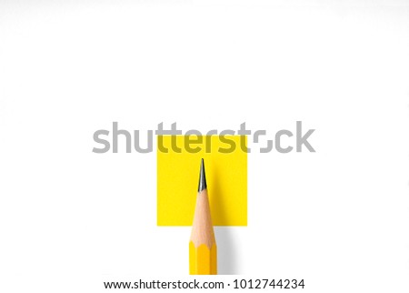 Minimalist template with copy space by top view close up macro photo of wooden yellow pencil isolated on yellow paper and combine with white square. Flash light made smooth shadow from pencil.