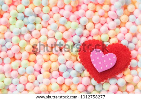 Valentine, wedding and love background concept. Pink and ted hearts on colorful small foam ball pattern in box with free copy space. Picture for add text message. Backdrop for design art work.