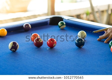 Man's hand and arm playing snooker in bar. Snooker ball on snooker table. Background. Copy space.