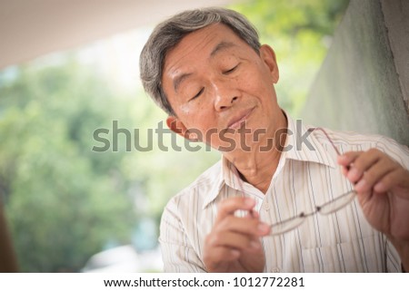 senior with eyesight, seeing, optical problem, old man looking at his glasses Royalty-Free Stock Photo #1012772281