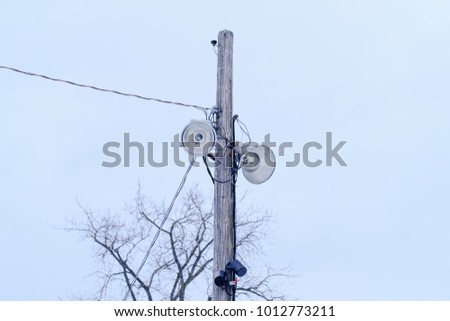 Street lamps on an old wooden pole during a winter day. Old wooden pillars with two street lamps. Great rural landscape with street lamps on wooden pillar. Electricity network in Canadian park.