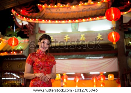Portrait of beautiful asian woman wear cheongsam on light of lantern background,Happy chinese new year,Thailand people