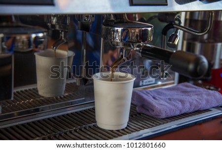 Hot coffee slowly flows through the coffee machine into the glass slowly.
