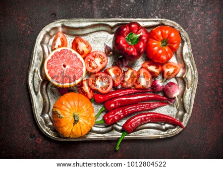 Red organic food. Fresh fruits and vegetables on a steel tray. On a rustic background.