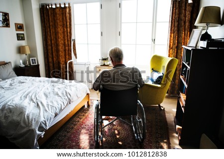 Senior man sitting on the wheelchair alone Royalty-Free Stock Photo #1012812838