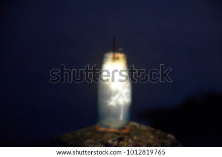 happy holidays.Vintage flim grain Style. Abstract blur background,Glass bottles There are fireworks.holding a burning sparkler light with purple sky background.closeup in female hand in dark.