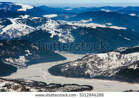 Ceahlau mountain view of frozen lake, Bicaz. Romania