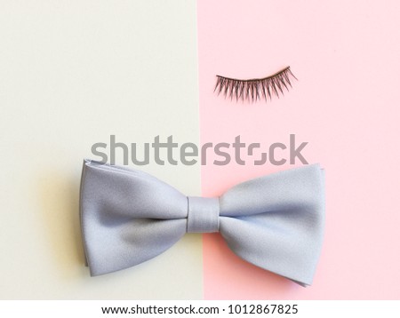 one eyelash and bow tie on half tone background. Idea for beauty fashion concept or symbolic of homosexuality