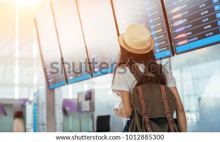 Asian teenage girl is using a smartphone to check flight at the international airport to travel on weekends. Royalty-Free Stock Photo #1012885300