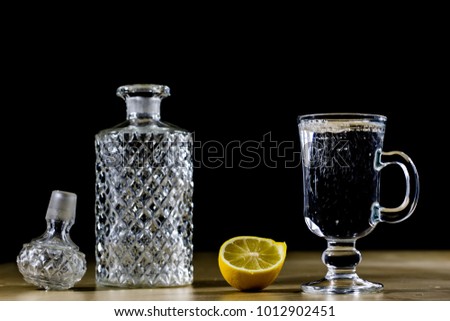 Carbonated drink in a glass bowl. Cool drink with bubbles and lemon. Black background.