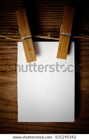 clothespin with blank white card on the wooden backgorund