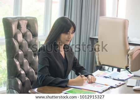 Charming businesswoman is using  laptop computer in the modern office.