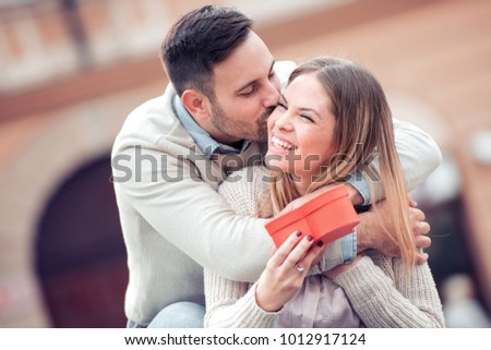 Man giving a gift to his girlfriend for Valentines day.