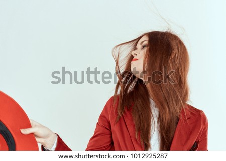  woman looking away in hand red hat on light background                              