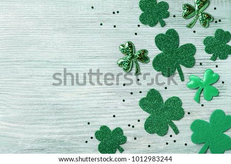 Saint Patricks Day background with green shamrock on white rustic board top view.